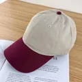 Close-up of a two-tone baseball cap in beige and burgundy on a minimalist background - Adjustable / Beige and Wine Red Brim