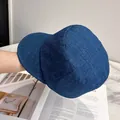 Detailed texture of navy linen newsboy cap held over a vintage magazine background - Adjustable / Vintage Blue