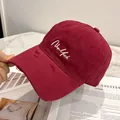 Dettaglio del ricamo su cappellino da baseball bordeaux in cotone con effetto usurato - Borgogna