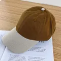 Detailed top view of a two-tone cotton baseball cap with embroidered eyelets on a desk - Adjustable / Camel and Beige Brim