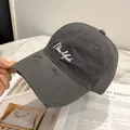 Dettaglio del cappellino in cotone grigio antracite con ricamo New York e visiera usurata - Grigio