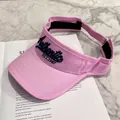 Dettaglio visiera parasole rosa con ricamo blu su sfondo di rivista e marmo grigio - Regolabile / Tutto Rosa