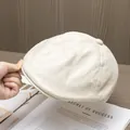 Dettaglio del berretto newsboy beige con trama intrecciata traspirante e bottone - Taglia unica / Beige