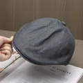 Detail der grauen Tweed-Stoffstruktur und des Knopfes auf der Rückseite dieser Schirmmütze - Einheitsgröße / Grau
