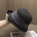 Détail d'un chapeau de paille tressé avec étiquette de protection UV et ruban gris chic - Noir
