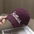 Dettaglio del ricamo e dei fori usurati sul cappellino da baseball in cotone bordeaux - Regolabile / Viola Rosa