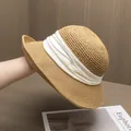 Détail d'un chapeau de paille kaki tissé avec un ruban élégant en tissu plissé blanc - Kaki