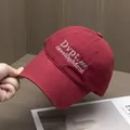 Détail de la broderie Dvpt sur casquette de baseball en coton sergé bordeaux de qualité - Réglable / Bordeaux