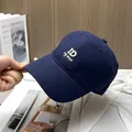 Close-up of white ID embroidery on a navy blue cotton twill baseball cap with peak - Navy Blue