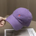 Close-up of a purple cotton baseball cap featuring a small red heart embroidery detail - Adjustable / Purple