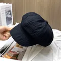 Detailopname van de geplooide textuur en stof van deze zwarte baret met klep voor dames - Verstelbaar / Zwart