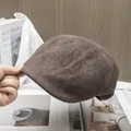 Detailed view of stitching on dark brown faux suede beret held by hand in a retro setting - Adjustable / Coffee