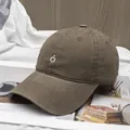 Detalle de gorra de béisbol de algodón marrón café con bordado blanco sobre fondo de textura - Ajustable / café