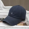 Detail of navy blue cotton baseball cap featuring minimalist white embroidered logo - Adjustable / Navy Blue with White Embroidery