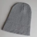 Detailaufnahme der gerippten Textur einer langen grauen Strickmütze für den Winter - Verstellbar / Hellgrau