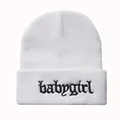 Detailaufnahme der Babygirl-Stickerei auf weißer Strickmütze mit gotischer Schrift - Weiß