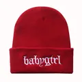 Detail der weißen babygirl Stickerei auf einer dunkelroten Strickmütze mit Rippstruktur - Burgunderrot