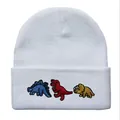 Detailansicht von drei bunten Cartoon-Dinosaurier-Stickereien auf weißer Beanie - Verstellbar / Weiß
