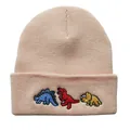 Detailansicht der drei Dinosaurier-Stickereien auf der beigen Strickmütze - Verstellbar / Khaki