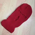 Detalle de pasamontañas de punto rojo con 3 agujeros y textura de canalé en madera - Burdeos