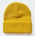 Detail der gelben Strickmütze mit vertikaler Rippenstruktur und klassischem Umschlagrand - Hellgelb