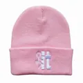 Detailaufnahme der pinkfarbenen Strickmütze mit weißem Stickmotiv im Streetwear-Stil - Rosa