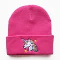 Detail der pinkfarbenen Strickmütze mit Einhorn-Stickerei und gerippter Textur - Verstellbar / Lederrot