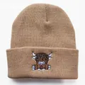 Detail of high-quality brown knitted beanie featuring a cartoon highland cow embroidery - Adjustable / Camel