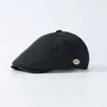 Gros plan sur une casquette vintage grise à carreaux avec petit patch décoratif lettre m - Réglable / Noir