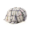 Close-up of distressed plaid newsboy cap with colorful ink splatters and vintage holes - One Size / Beige