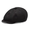 Detail view of the eight-panel crown and top button on a black cotton newsboy cap - Black