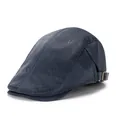 Detalle de boina de cuero azul oscuro con hebilla lateral metálica y costuras precisas - Azul marino