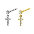 Macro shot of silver and gold cross pendant nose studs with cubic zirconia gems - Cross