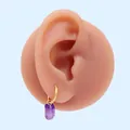 Minimalist gold hoop earrings with a translucent purple hexagonal crystal pendant on model - Purple Zirconia (Gold)