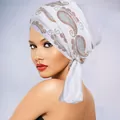 Close-up of white velvet turban with colorful rhinestone paisley pattern on smooth fabric - White