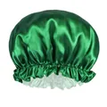 Close-up of emerald green satin sleep cap with ruffled elastic band and smooth texture - Green