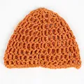 Macro detail of ginger orange crochet mesh hat with hollow knit texture and fiber patterns - Orange