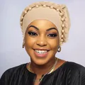 Dettaglio del design a treccia e perle bianche sul turbante beige da donna - Cachi