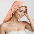 Silky coral satin sleep bonnet with elastic ruffled edge shown on a female model - Champagne