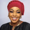 Dettaglio di un turbante rosso con perle e bordo intrecciato su una modella elegante - Borgogna