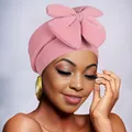 Close-up of pink turban headwrap with large bow knot and soft elastic fabric texture - Pink