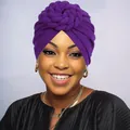 Detail of a purple braided twist turban hat showing the soft knitted fabric on a model - One Size / Purple