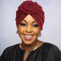 Close-up of a burgundy knit turban hat with a spiral braided flower knot for women - One Size / Burgundy