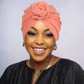 Close-up of coral knit turban hat featuring a spiral flower knot and soft texture - One Size / Dusty Pink