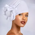 Close-up of white breathable headscarf with large handcrafted fabric flower detail - One Size / White