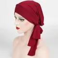 Dettaglio del turbante a coste bordeaux con nodo a croce frontale e coda su un modello - Taglia unica / Borgogna