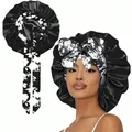Detail of satin bonnet with floral printed bow showing texture and secure fit - One Size / Black and White Floral Tie Style / Black