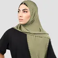 Vista detallada del hiyab verde oliva con pedrería intrincada y seda de leche elástica - Verde matcha