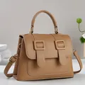 Detailed macro of light brown pebble leather texture and gold buckle hardware - Khaki