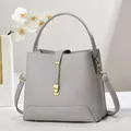 Detail of grey lychee leather handbag with gold metal clasp and orchid decor - Gray